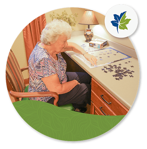 older-woman-doing-a-puzzle-at-a-desk older woman doing a puzzle at a desk